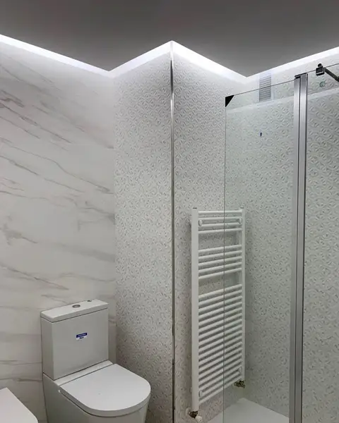 Baño con ducha de mampara e iluminación